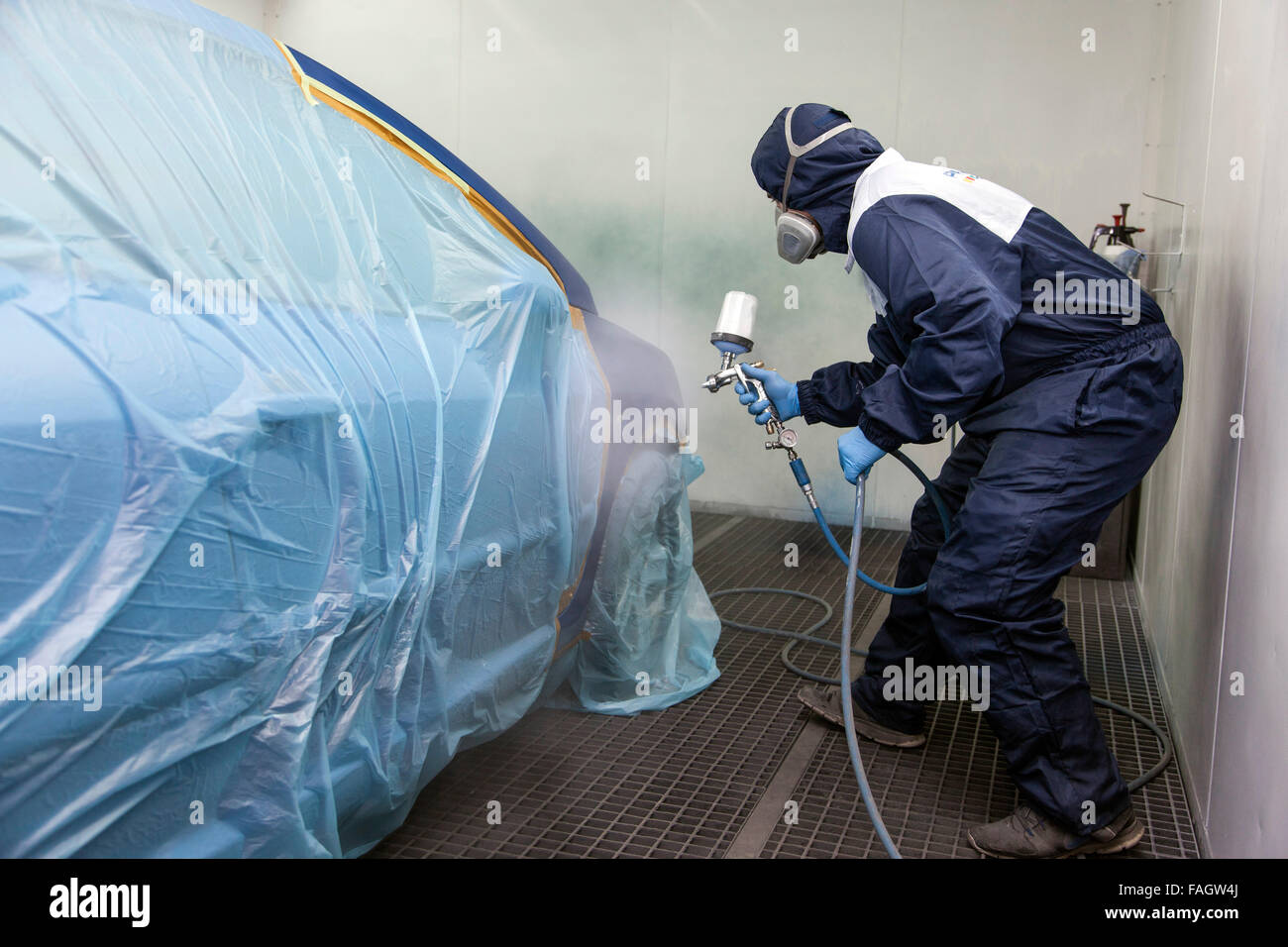 Vehicle varnisher in the paint spraying cabin. Stock Photo