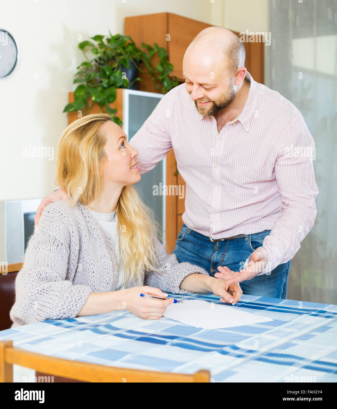 Positive couple discussing details of marriage settlement at home Stock