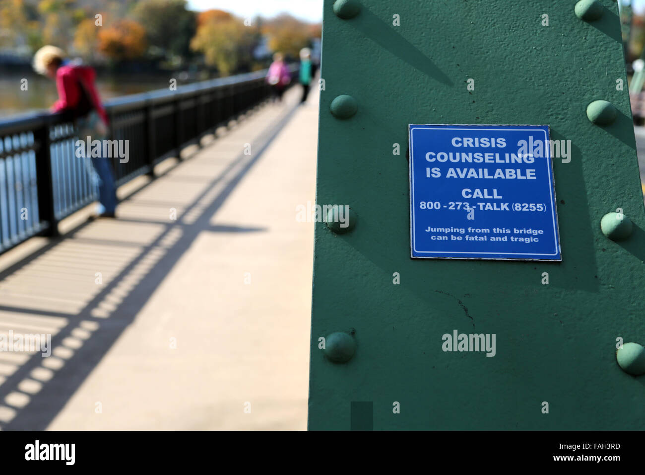 A bridge sign warning for suicidal people with telephone numbers for crisis counseling Stock Photo