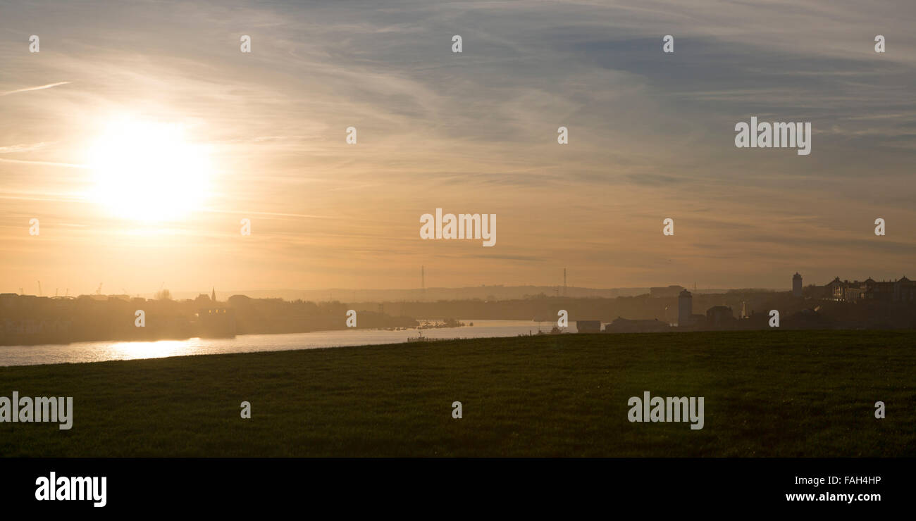 The mouth of the River Tyne between South and North Shields, England. The low sun reflects on the waterway. Stock Photo