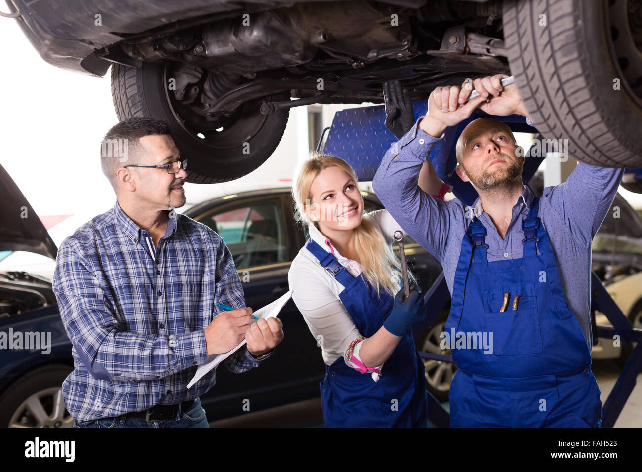 Professional Mechanics With Supervisor Repairing Car At Workshop Stock ...