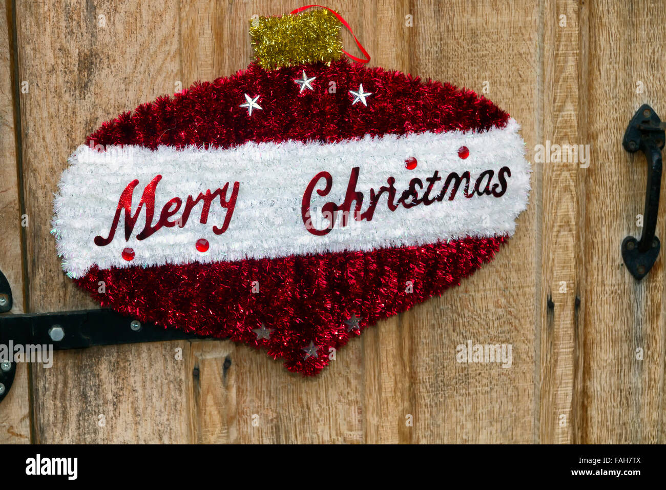 Merry Christmas sign in the shape  of a Christmas ball ornament on a wooden door Stock Photo