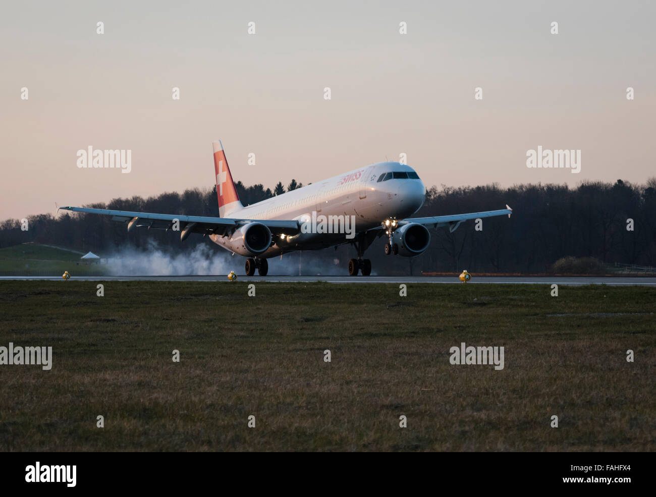 Landing Airbus A320 passenger aircraft of Swiss International Air Lines with smoking tires at Zurich Kloten airport. Stock Photo