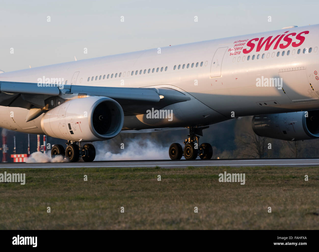 Landing Airbus A330-300 passenger aircraft of Swiss International Air Lines with smoking tires at Zurich Kloten airport. Stock Photo