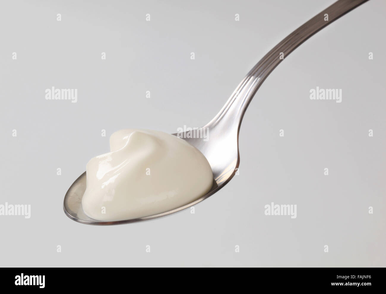 Spoonful of smooth plain yogurt Stock Photo Alamy