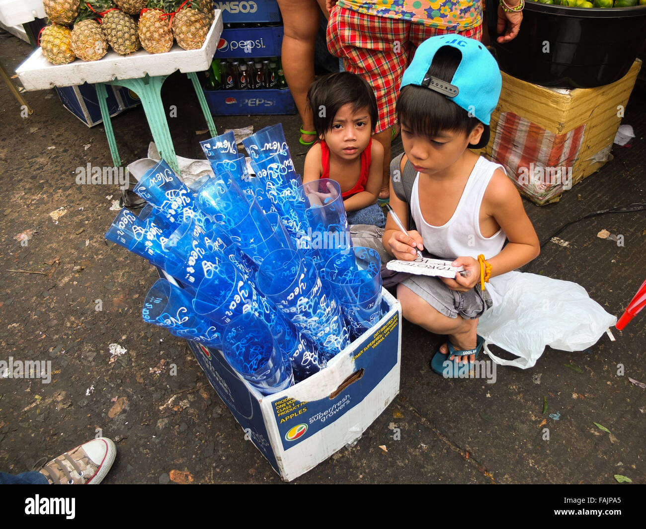This child calculating his earnings by selling hornpipes products at Divisoria in Manila. Filipinos anticipation of the last celebration on the calendar, The New Year's Eve with much merry making and superstitious belief on rounded fruits, It believes that it could bring luck. (Photo by Josefiel Rivera / Pacific Press) Stock Photo