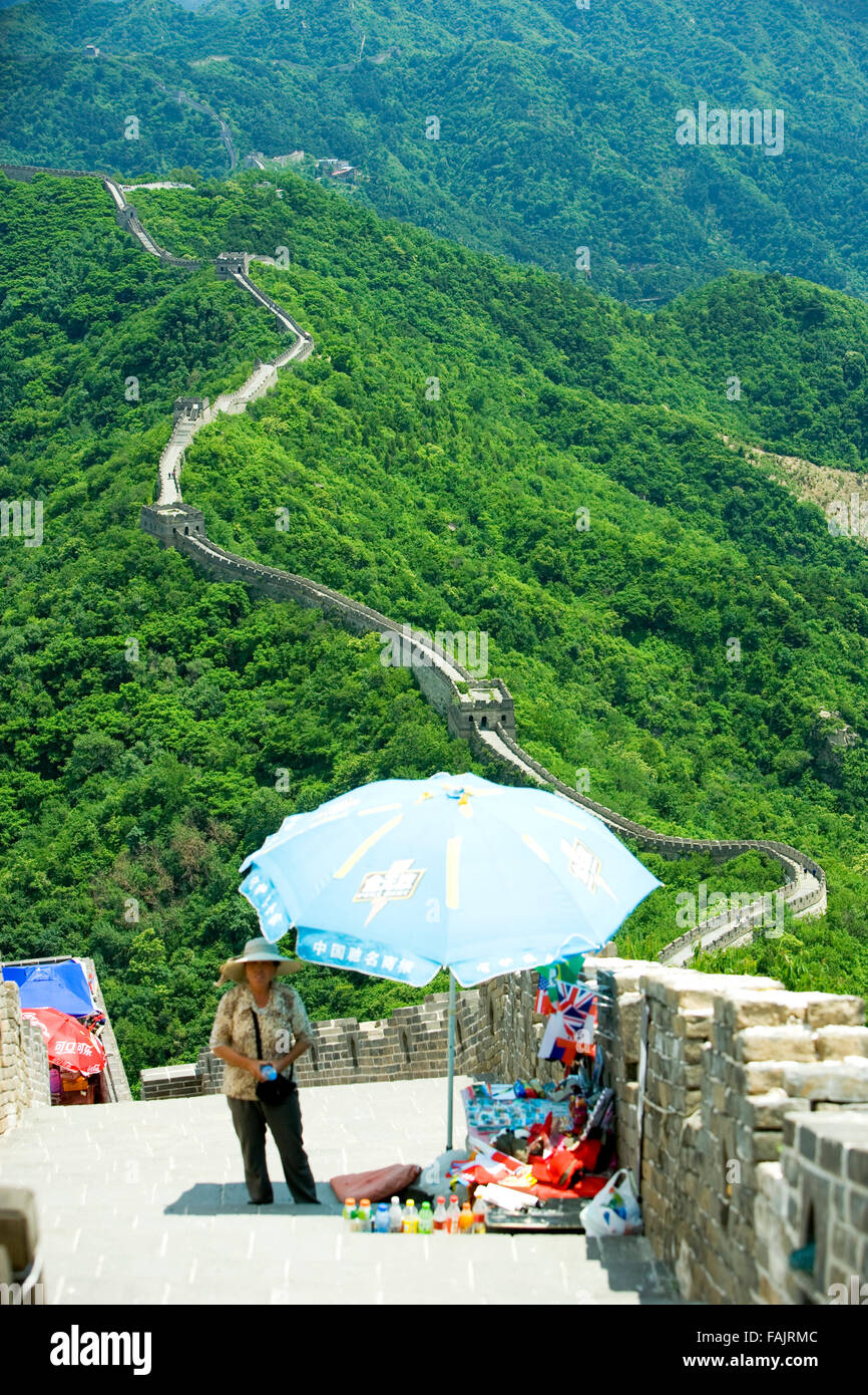 Chinese woman selling cold drinks ,hats, bags on the Great Wall of China, UNESCO World Heritage Site, Beijing District, China Stock Photo