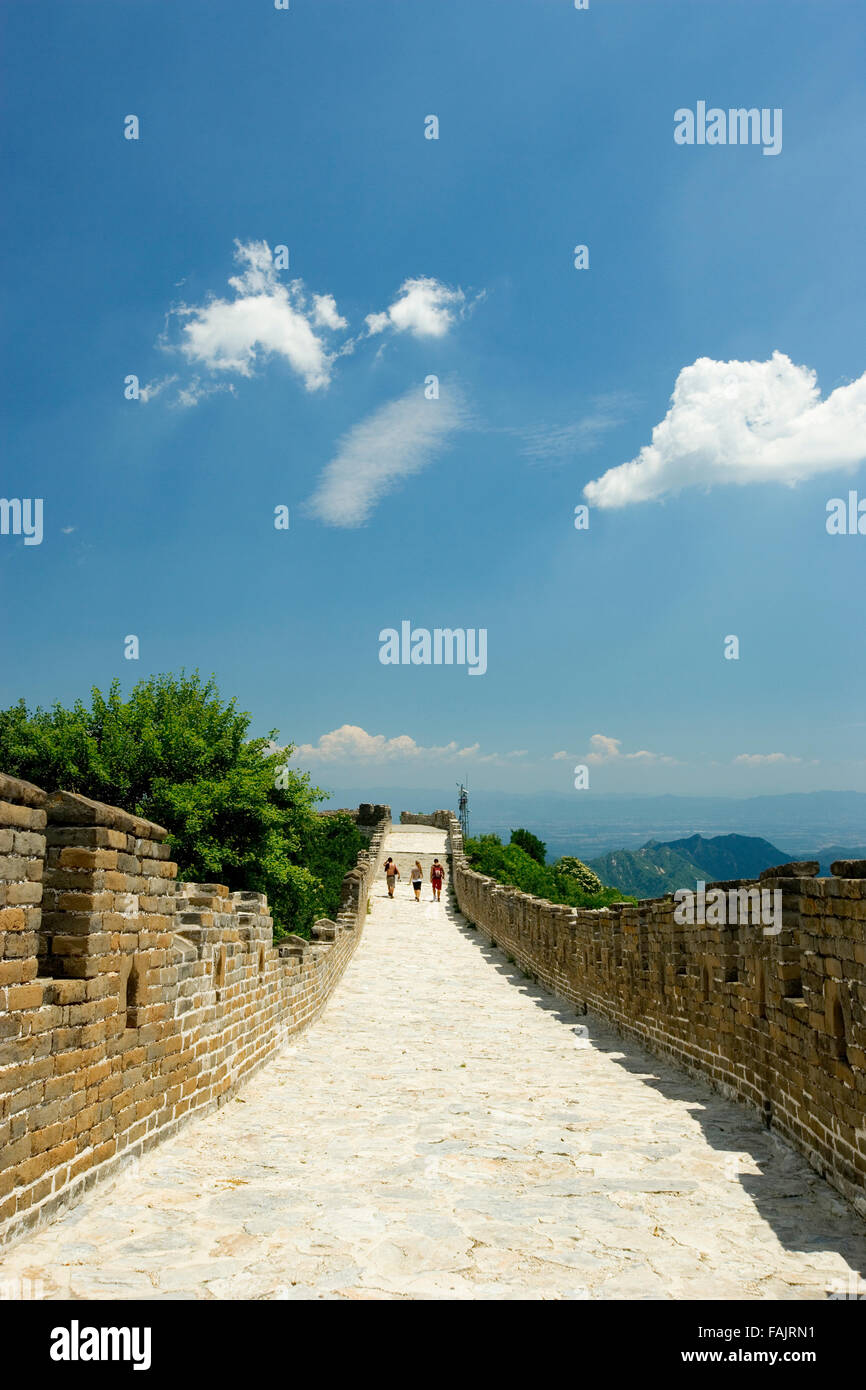 three people walking along a section of the Great Wall, Jinshanling, China. Stock Photo