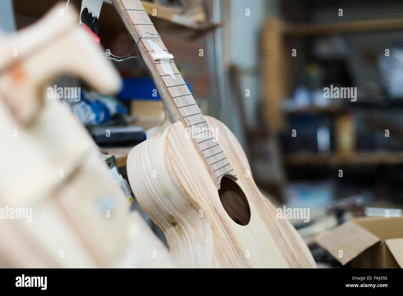 Unfinished acoustic guitar and equipment at background Stock