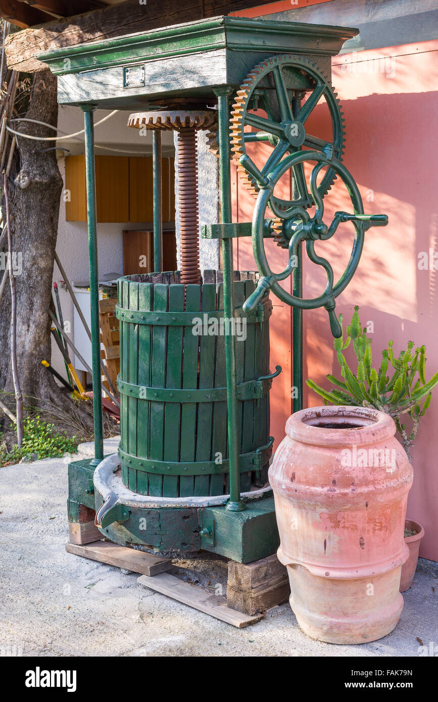 Vintage olive press, traditionally used to make oil in the mediterranean area, with his wooden barrel, green painted. Stock Photo