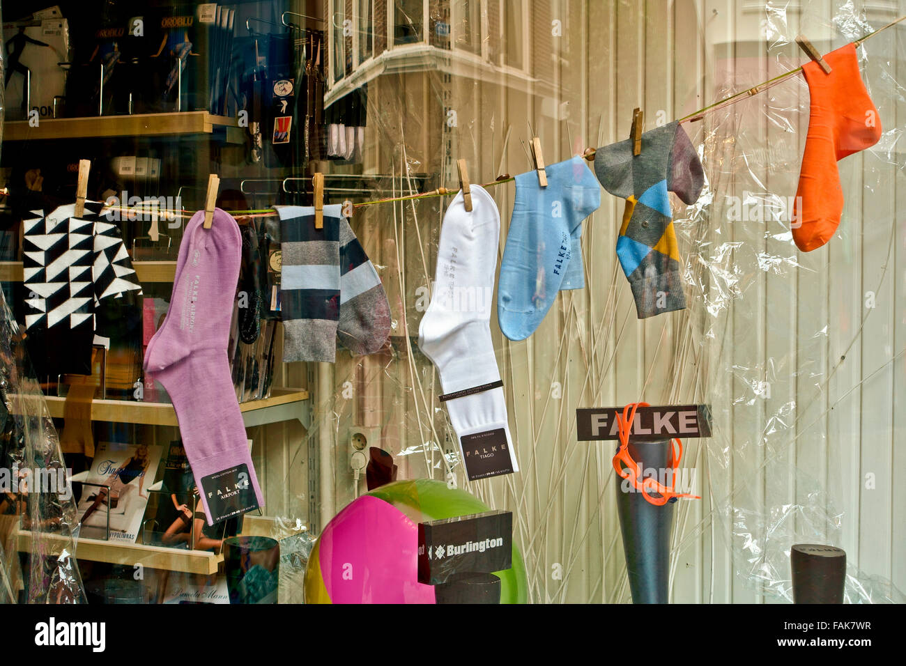 Display of men's colourful socks hang in a shop window. Shop store