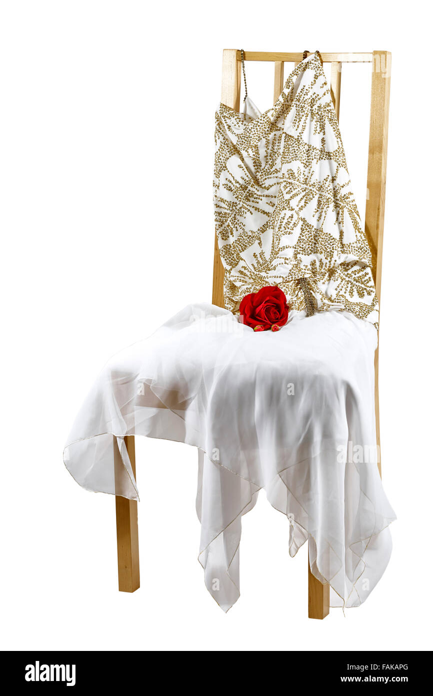 Woman's white evening dress with sequins, rhinestones and a rose draped over a chair isolated on white Stock Photo