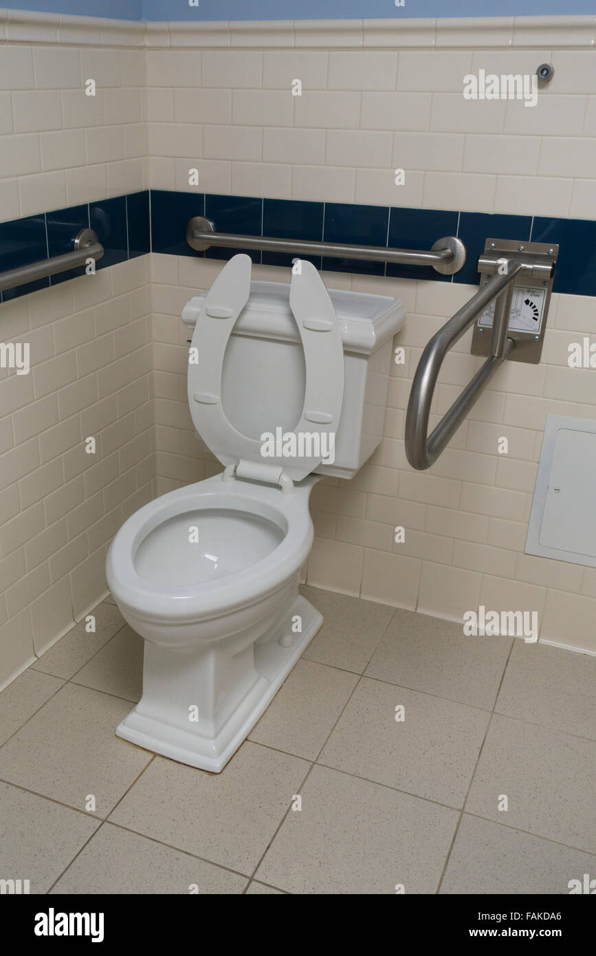 toilet in empty bathroom with safety rails Stock Photo Alamy