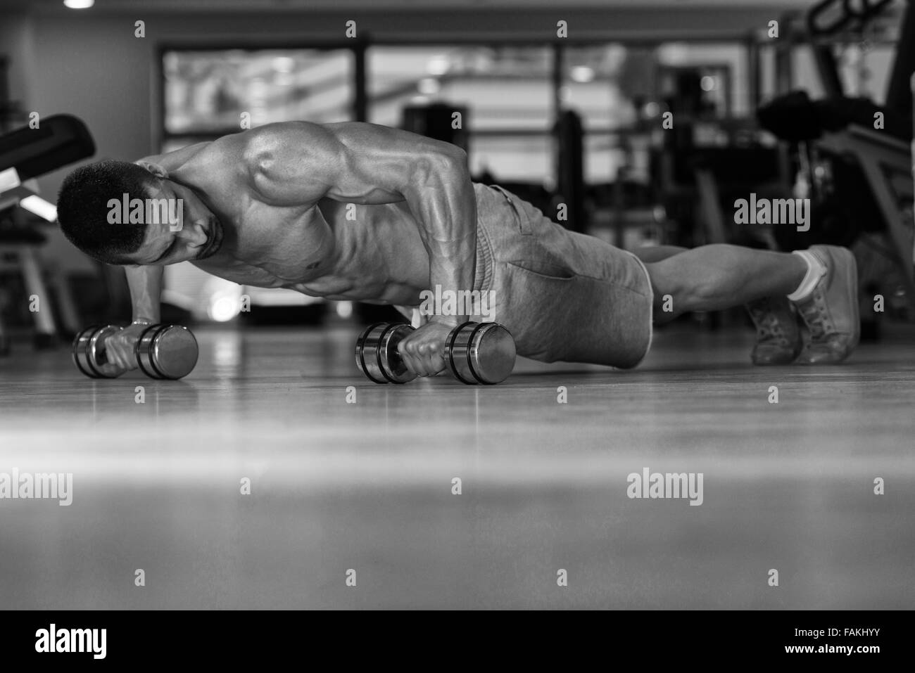 Young Athlete Doing Pushups With Dumbbells As Part Of Bodybuilding