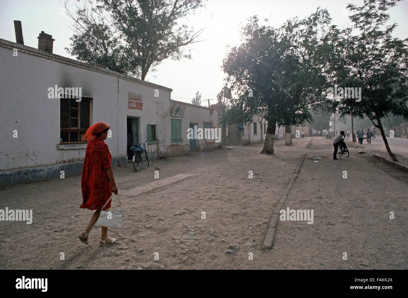Uyghur woman walking through Turpan,  Xinjiang Province, China Stock Photo