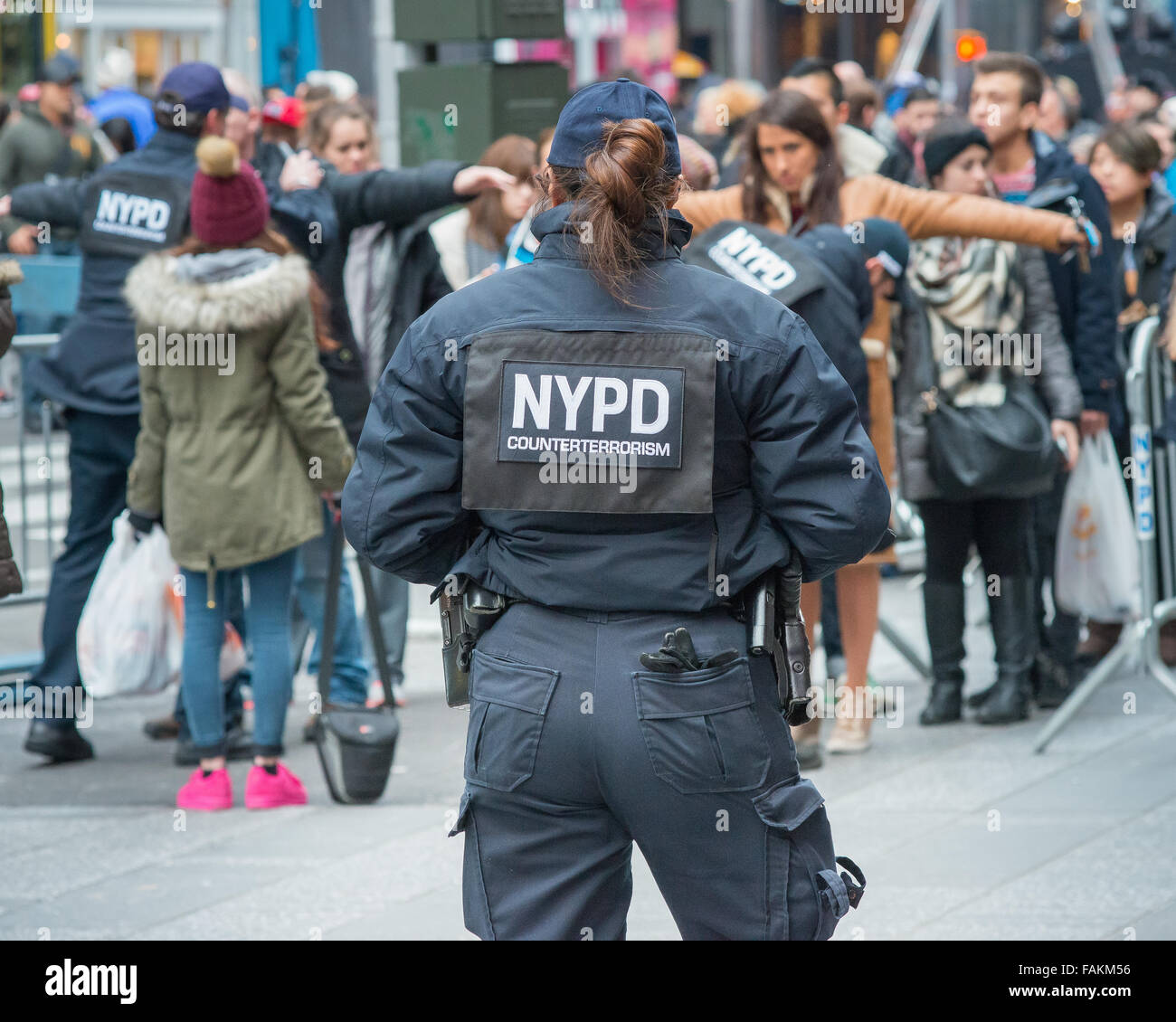 New York, United States. 31st Dec, 2015. A NYPD counterterrorism officer (foreground) keeps an eye on the proceedings at a spectator checkpoint. With a heightened degree of security due to the threat of a terrorist strike like those in Paris and San Bernadino, preparations for New York City's annual Times Square New Year's Eve celebration reflect the city's resolve to maintain public safety at such mass public gatherings. Credit:  Albin Lohr-Jones/Pacific Press/Alamy Live News Stock Photo