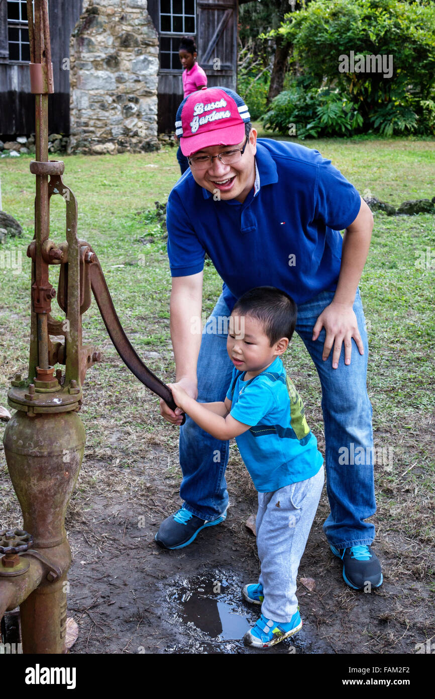 Gainesville Florida,Dudley Farm State Park,Homestead & Living History Museum,property,Asian man men male,father,boy,son,water pump,well,pumping,teamwo Stock Photo
