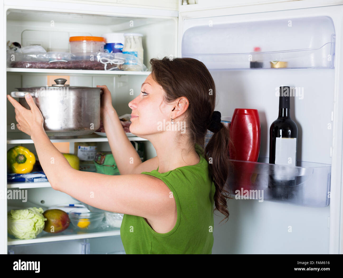 Housewife opening refrigerator at domestic kitchen Stock Photo