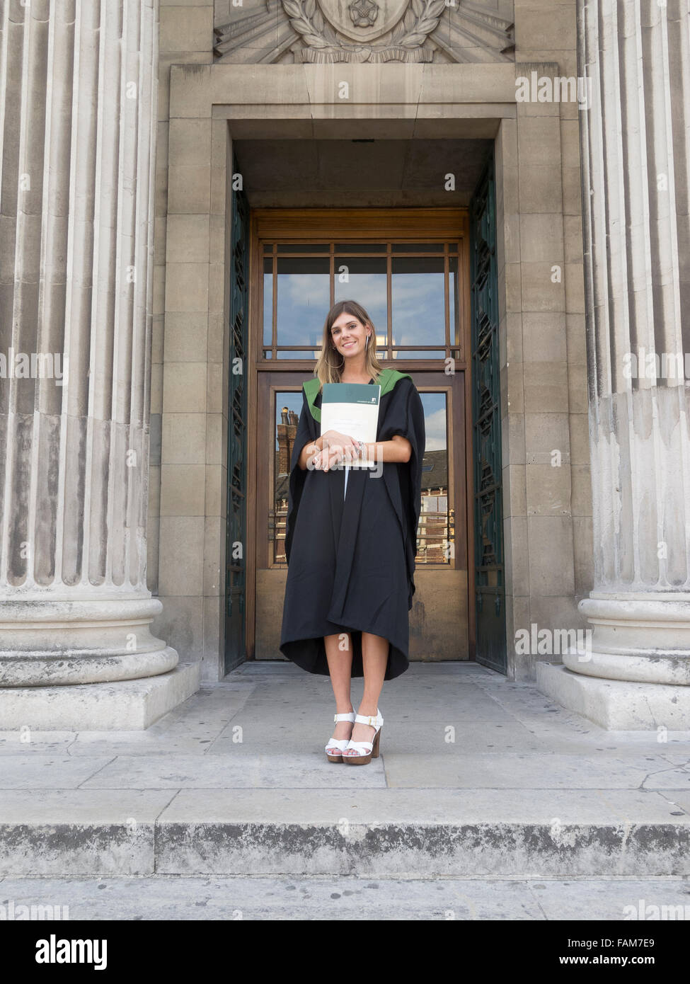 A smiling student at Leeds University in her gown on graduation day. Stock Photo