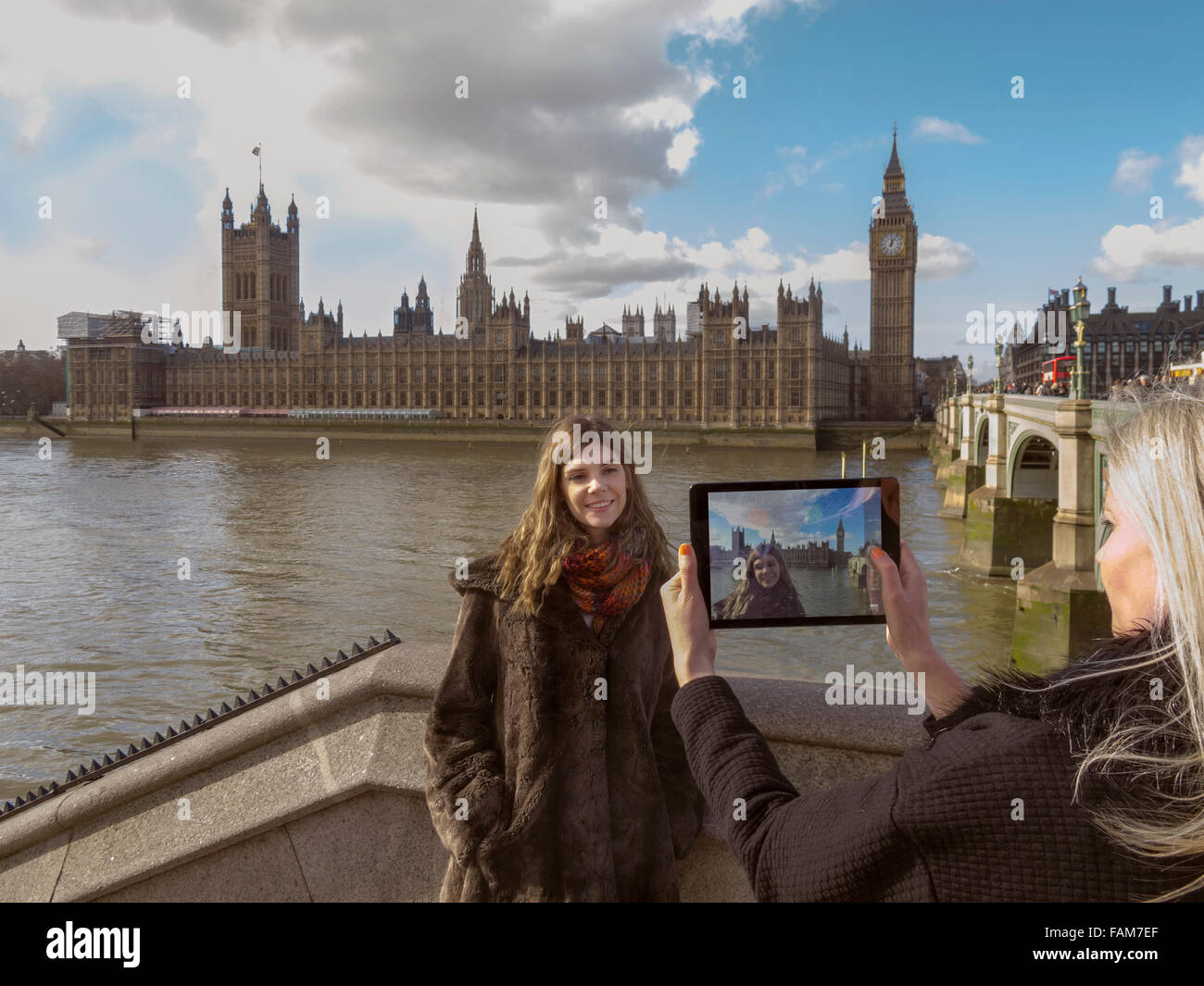 Tourists using an iPad to photograph themselves in front of the Houses of Parliament, London, UK. Stock Photo