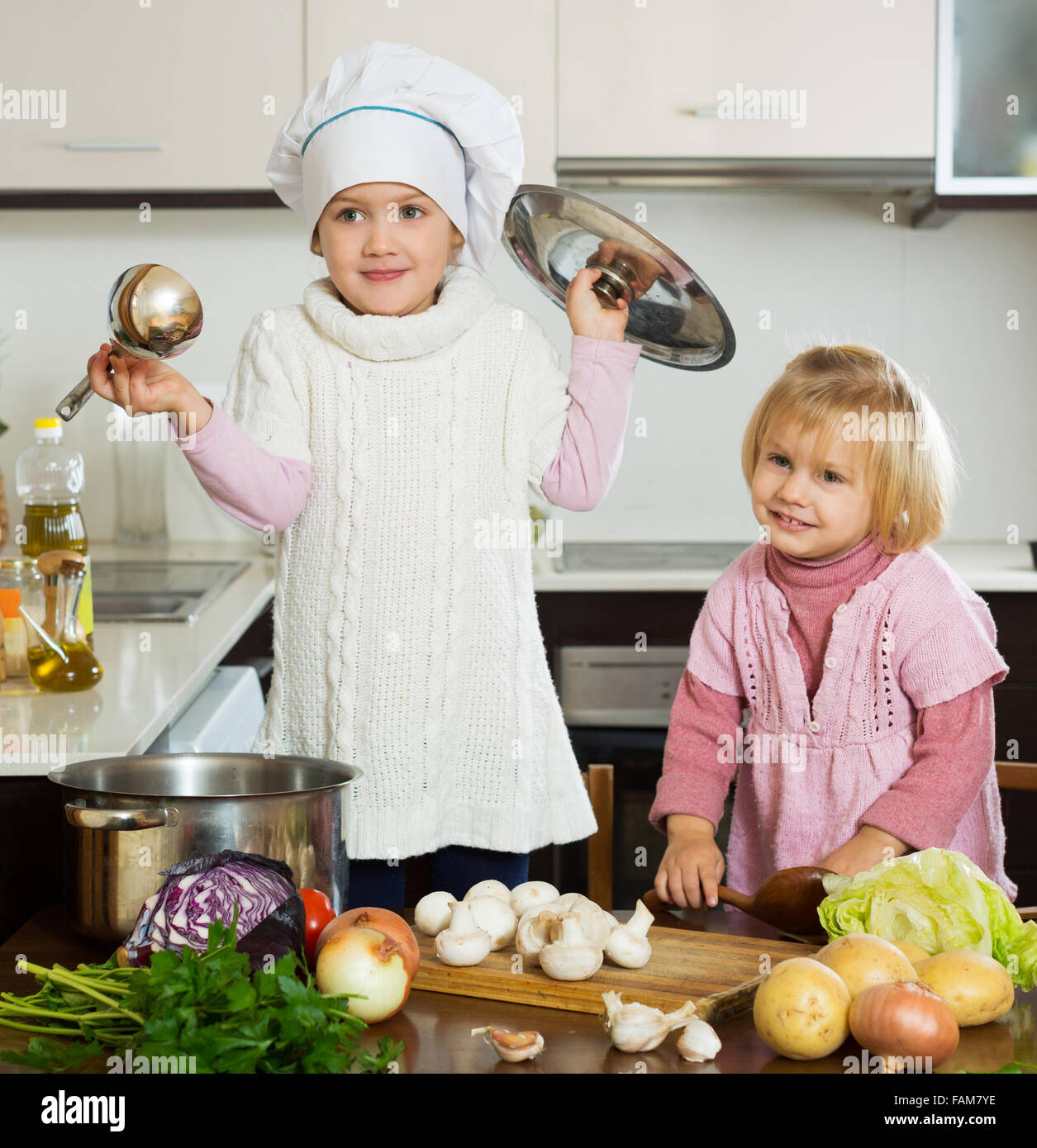 Happy children preparing vegetable soup in kitchen Stock Photo - Alamy