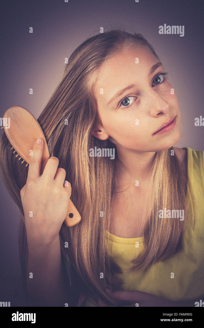 Blonde girl combing her hair, grain effect, vintage, old fashion Stock Photo