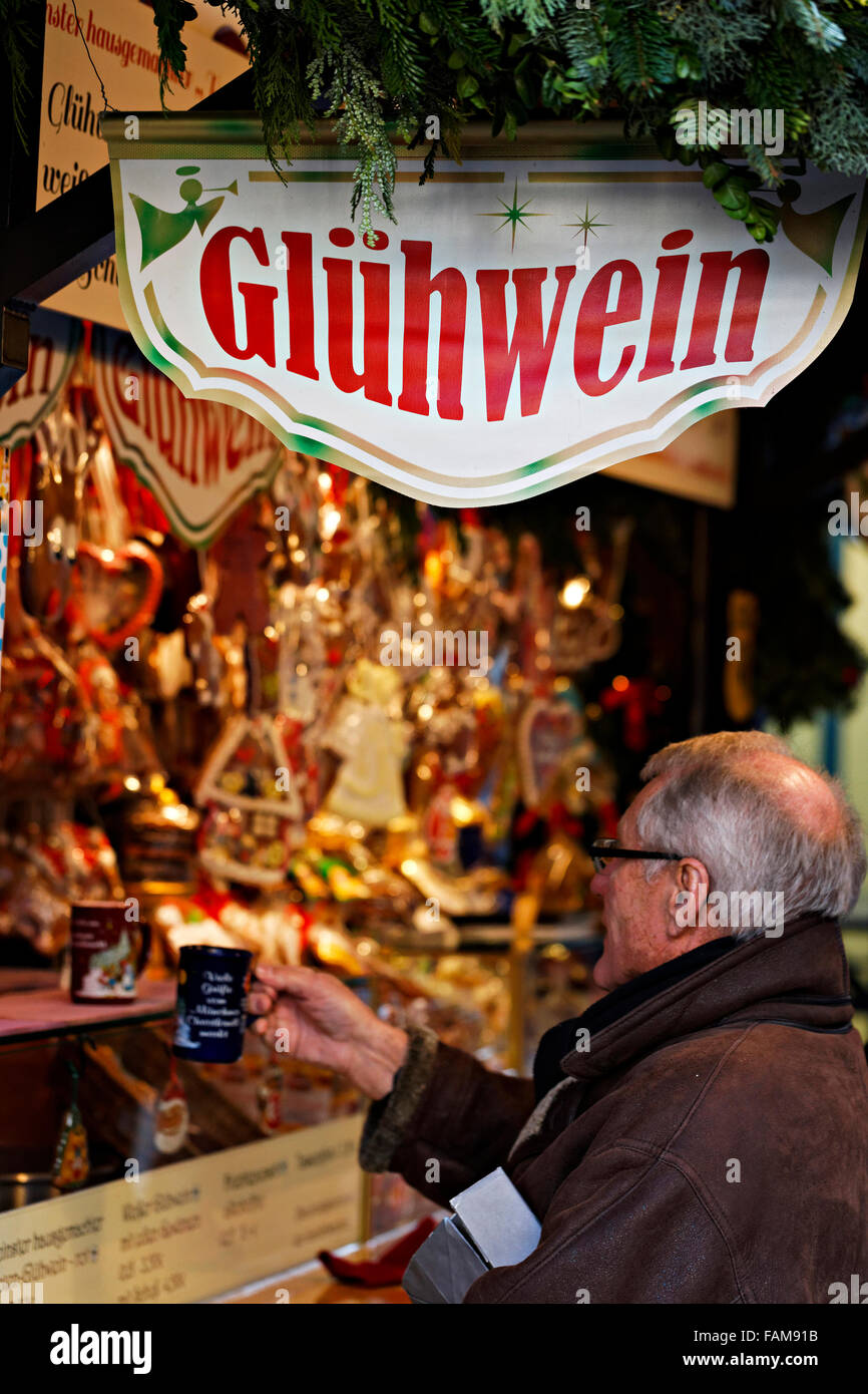 Man holding a mug of Gluhwein (mulled wine ) at a christmas market stall, Munich, Upper Bavaria