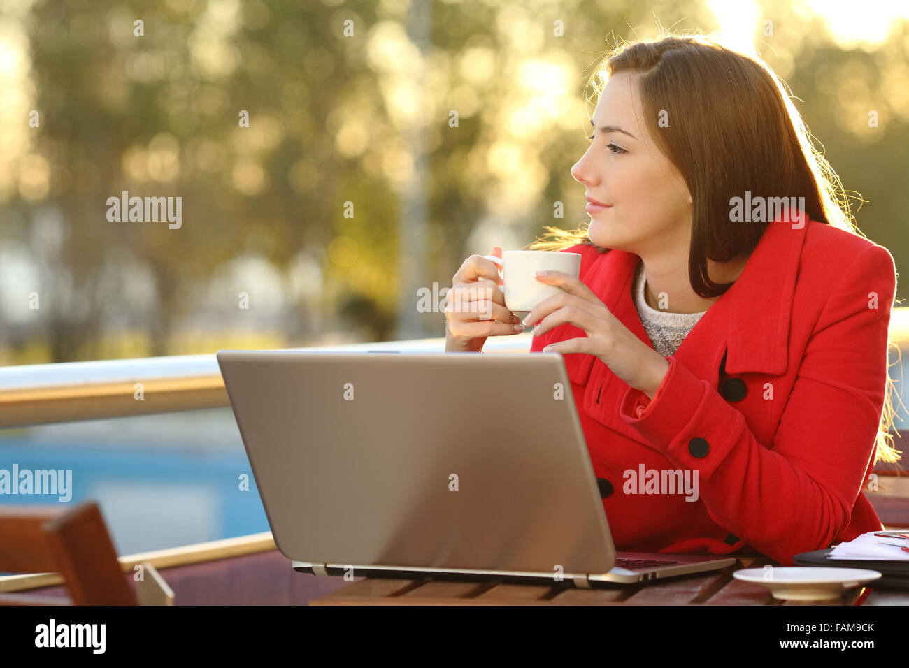 Entrepreneur with a laptop relaxing in a coffee shop and looking forward Stock Photo