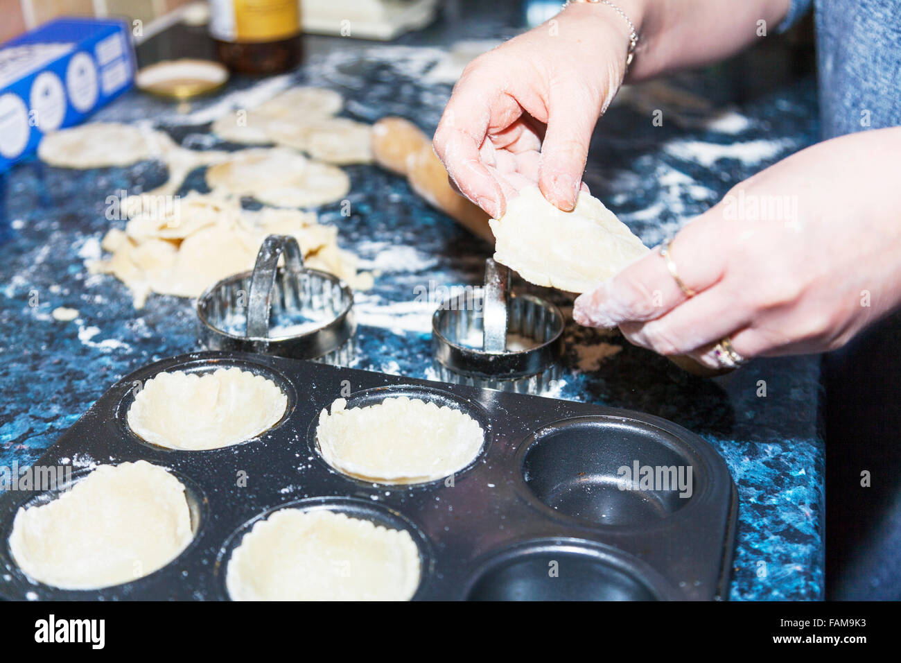 Putting pastry cases in tray baking cooking in the kitchen shapes cut out by cutter Stock Photo
