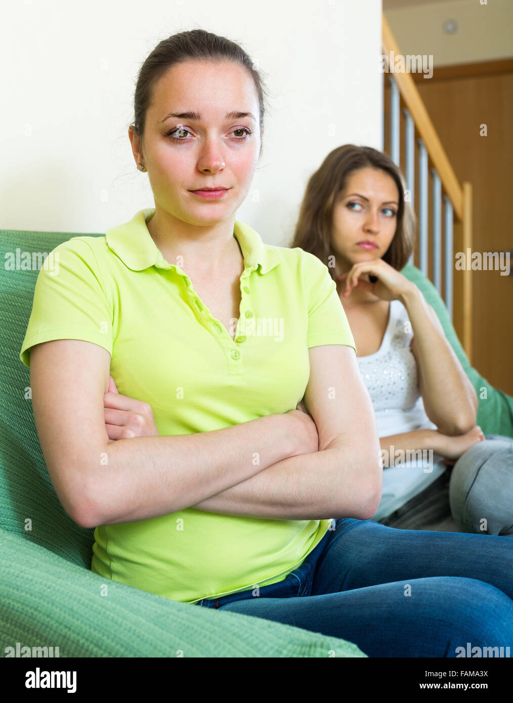 Two young unpleased women after quarrel at home Stock Photo