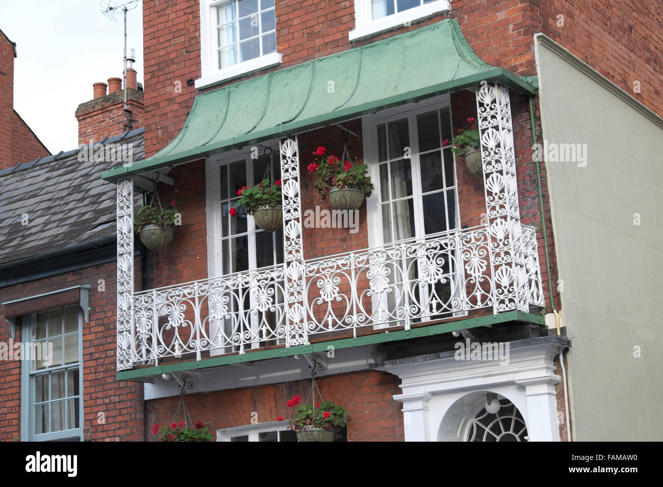 Hereford UK ornate ironwork balcony with flower baskets on a property in Castle Street, Hereford Stock Photo