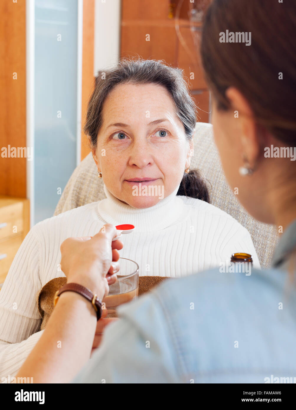 Woman giving the cough syrup to elderly mother at home Stock Photo Alamy