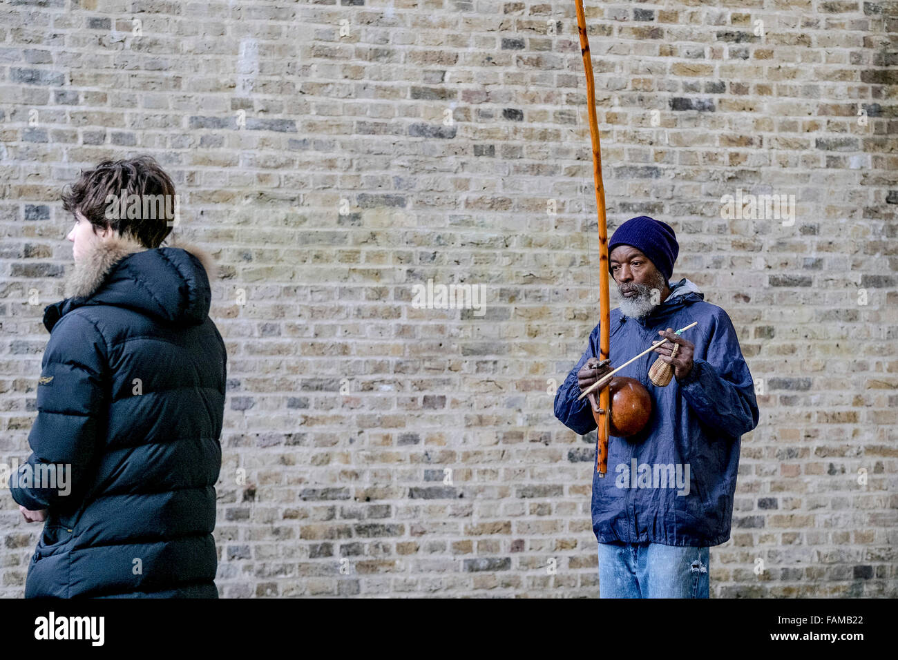 On the South Bank in London a busker, Rabimsha plays a berimbau, a traditional African/Brazilian instrument. Stock Photo