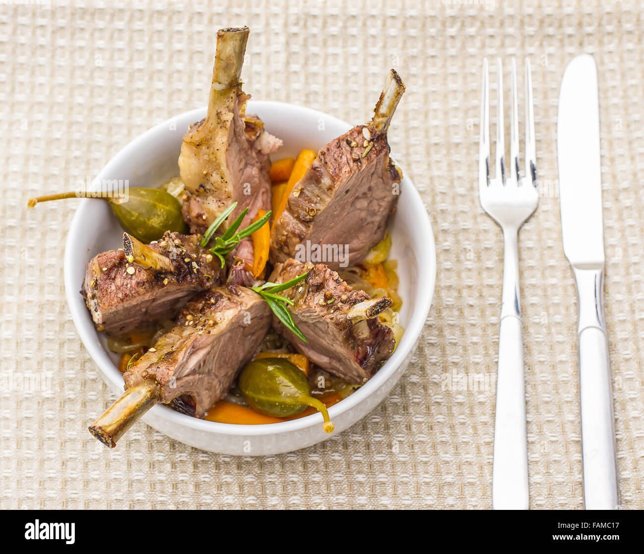 Grilled rack of lamb with carrot onion, garlic and rosemary, top view