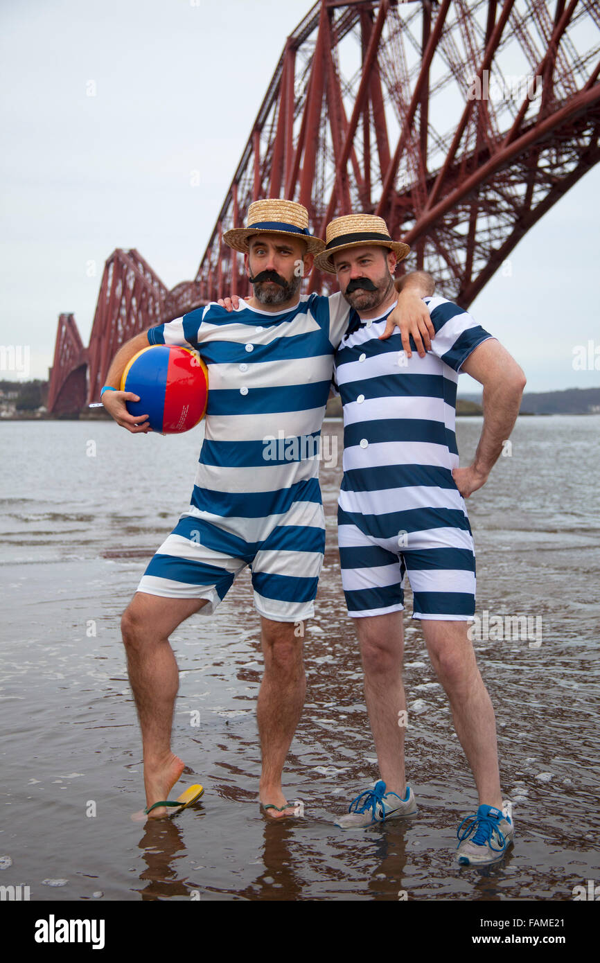 South Queensferry, Edinburgh, Scotland UK. 01 January 2016. Queensferry Loony Dook, the annual dip in the River Forth in the shadow of the world-famous Forth Rail Bridge. Takes place on the third day of the Edinburgh Hogmany New Year celebrations. The weather was fair but chilly between 2-4 degrees but this did not dampen the spirits of these hardy participants. Gonzales form Spain and Joe from Edinburgh Stock Photo