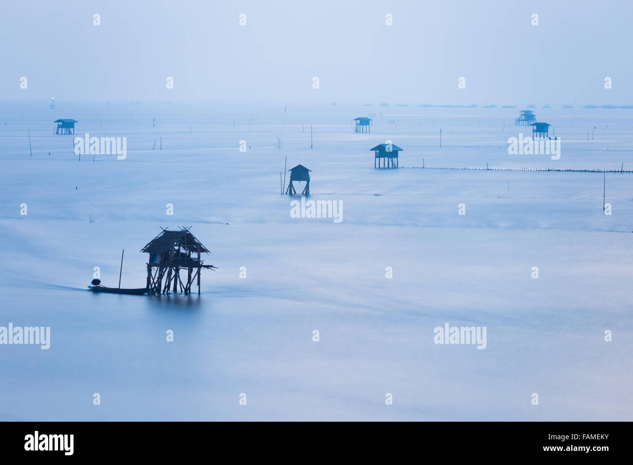 Mist cover sea and floating house during rainy morning Stock Photo