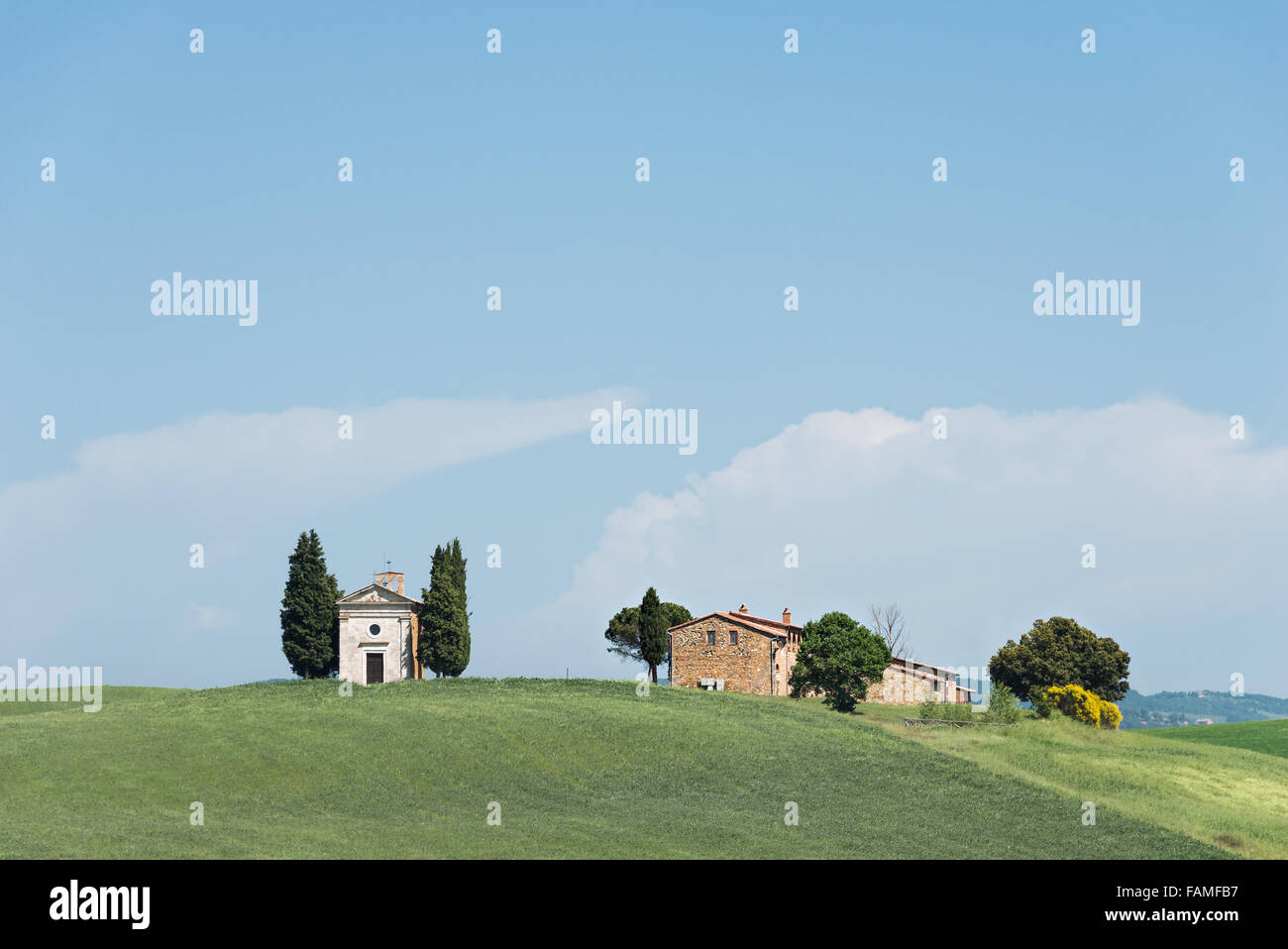 Cappella della Madonna di Vitaleta church with cypress trees and a farm in a field in the Orcia Valley in Tuscany, Italy. Stock Photo