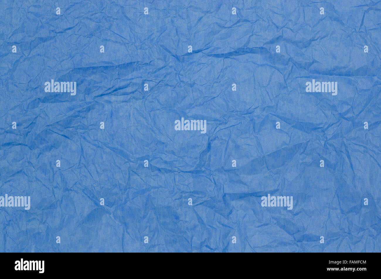 Crumpled colorful tissue paper on a blue tissue paper background