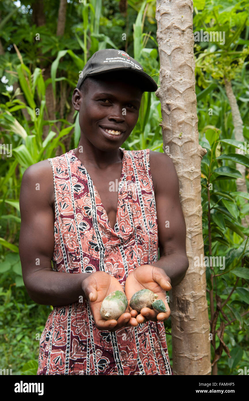Woman with freshly picked Papaya fruit, halved, showing seeds. Kenya. Carica papaya Stock Photo