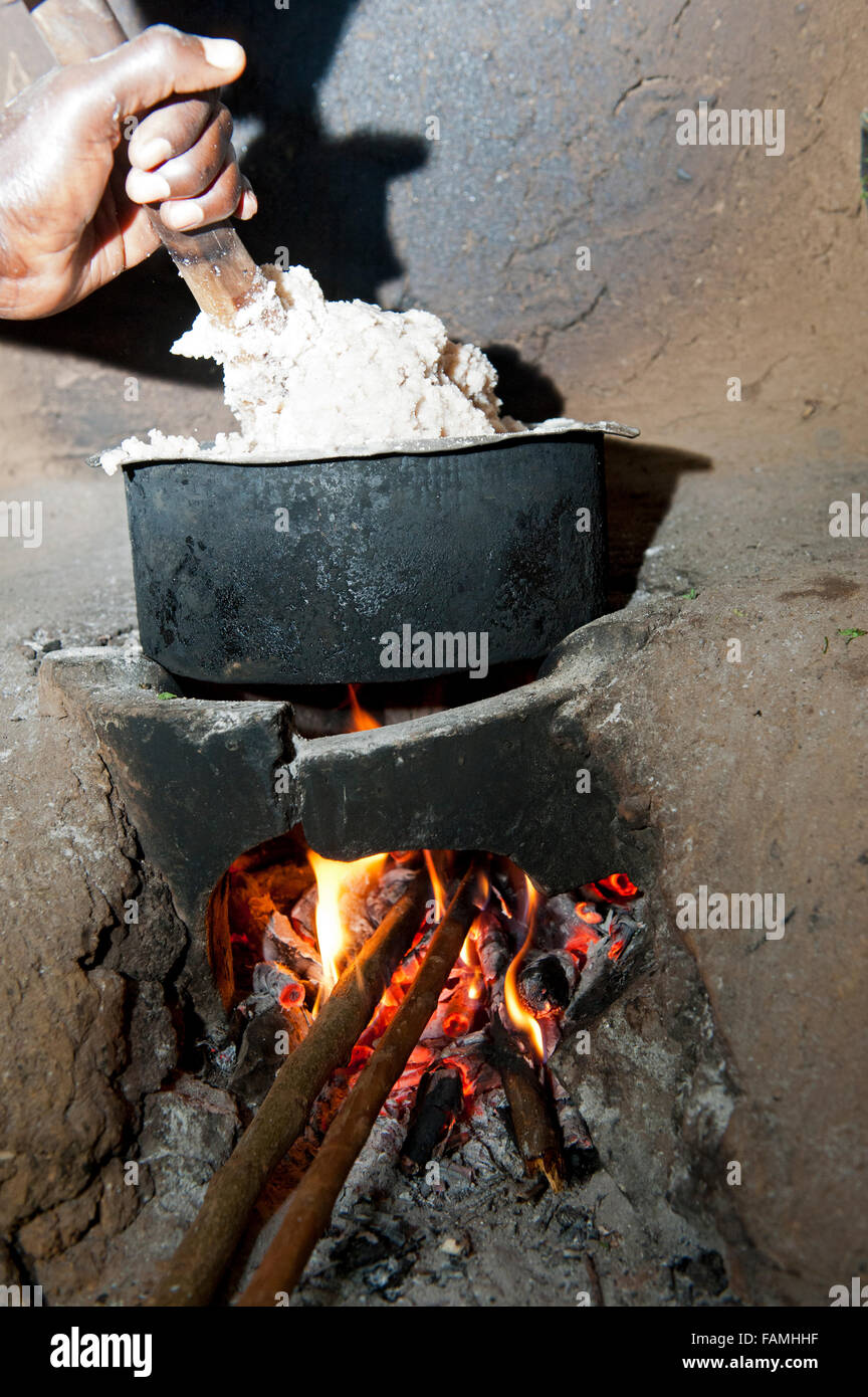 Cooking meal over an open fire in a small basic kitchen unit, Kenya. Stock Photo