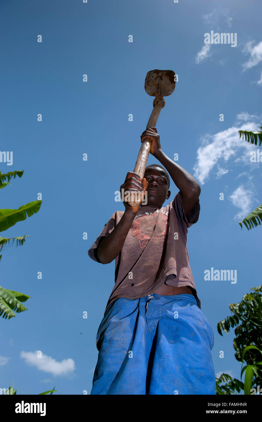 Young boy working in field with a traditional hoe. Kenya. Stock Photo