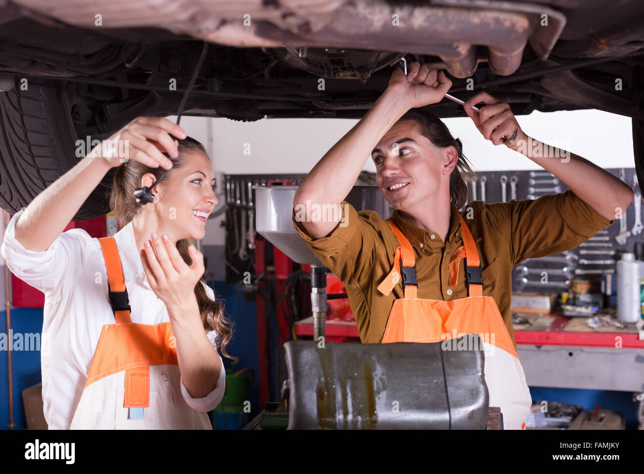 Handsome mechanic and beautiful female assistant working at auto repair ...