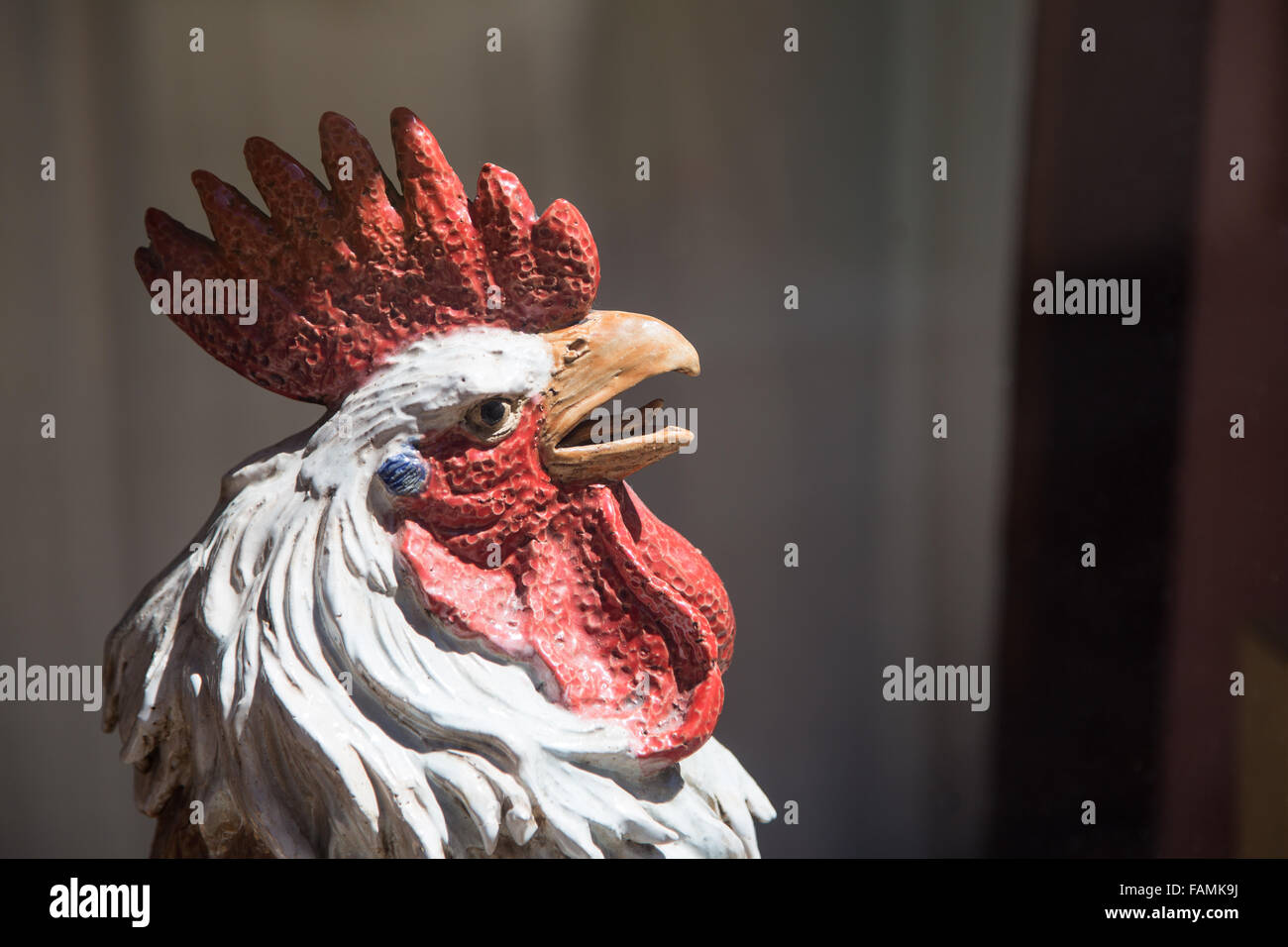 An antique porcelain patina cockerel/rooster bird head statue with a