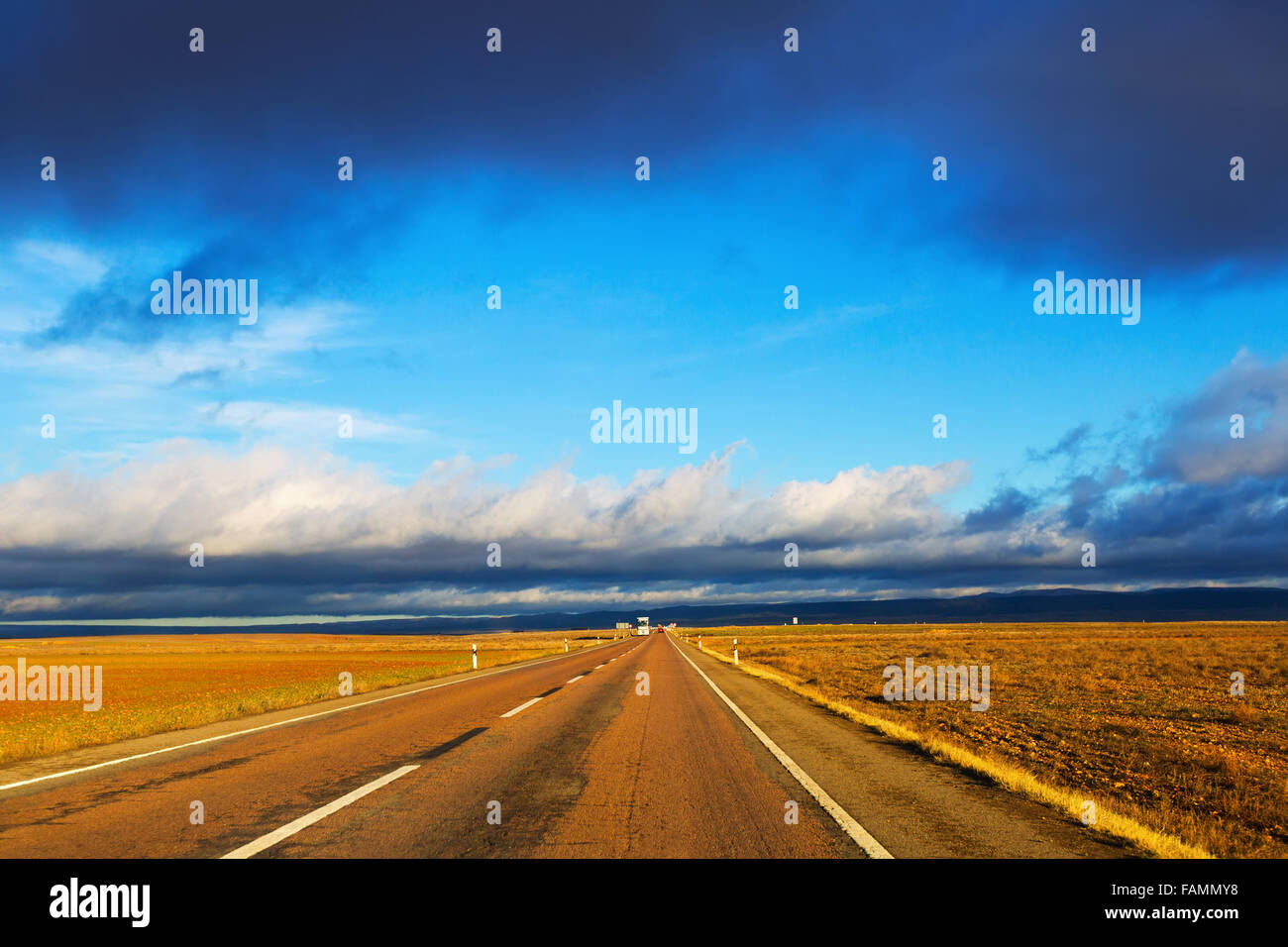 Asphalt road among fields under sky Stock Photo - Alamy