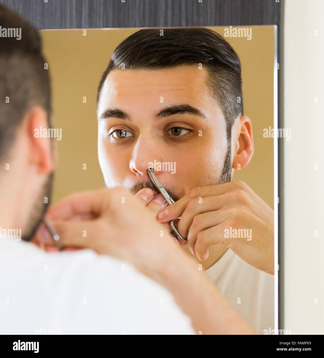 Handsome Young Male In Front Of Mirror Remove Hair From His Nose