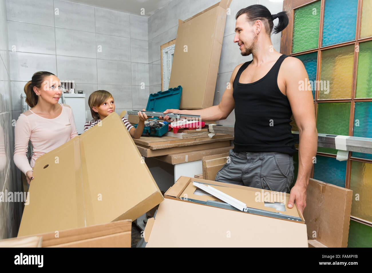 Happy Smiling Family Unpacking Boxes With New Furniture. Focus On Man ...