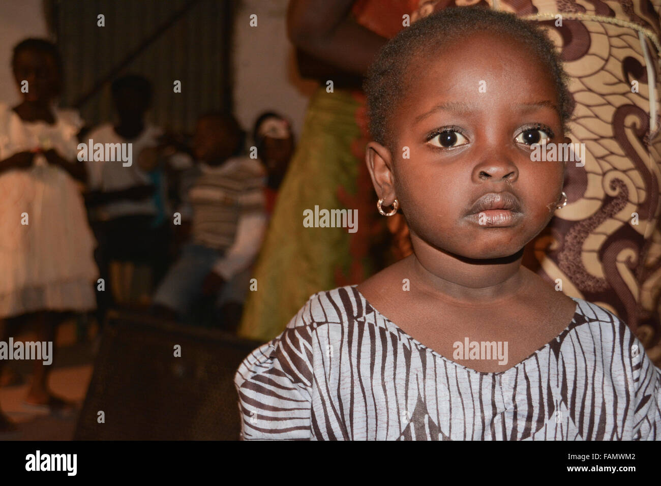 A portrait of a little Gambian girl. The girl is wearing blue pattern traditional outfit. Stock Photo