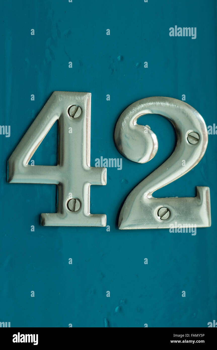 The number 42 in chrome on the front of a gloss teal front door. Stock Photo
