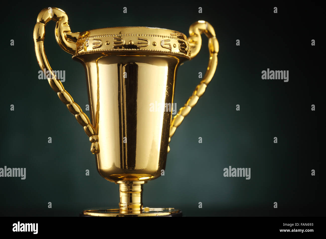 Golden trophy on green background Stock Photo - Alamy