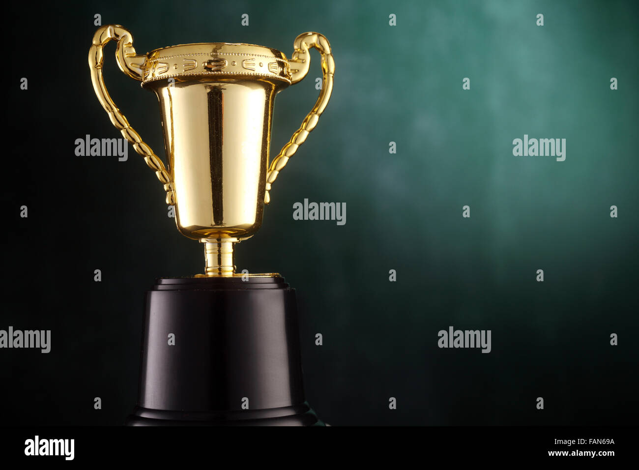 Golden trophy on green background Stock Photo - Alamy